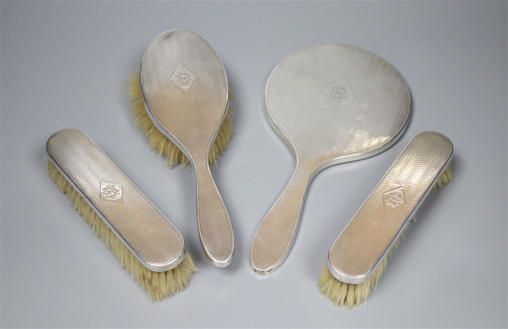 A 1920s engine turned silver mounted four piece mirror and brush set by Elkington & Co, Birmingham, 1925.